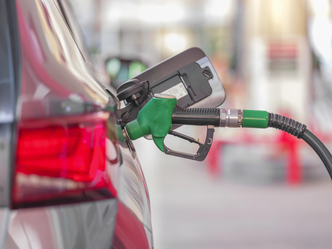 Pistolet vert de pompe à carburant engagé dans le réservoir d'une voiture